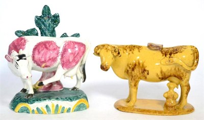 Lot 13 - A Creamware cow creamer and stopper, circa 1820, with milk maid and brown sponge decoration, on...
