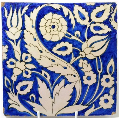 Lot 22 - A faience tile painted in blue, in 17th century, with stylised flowers, 20cm wide