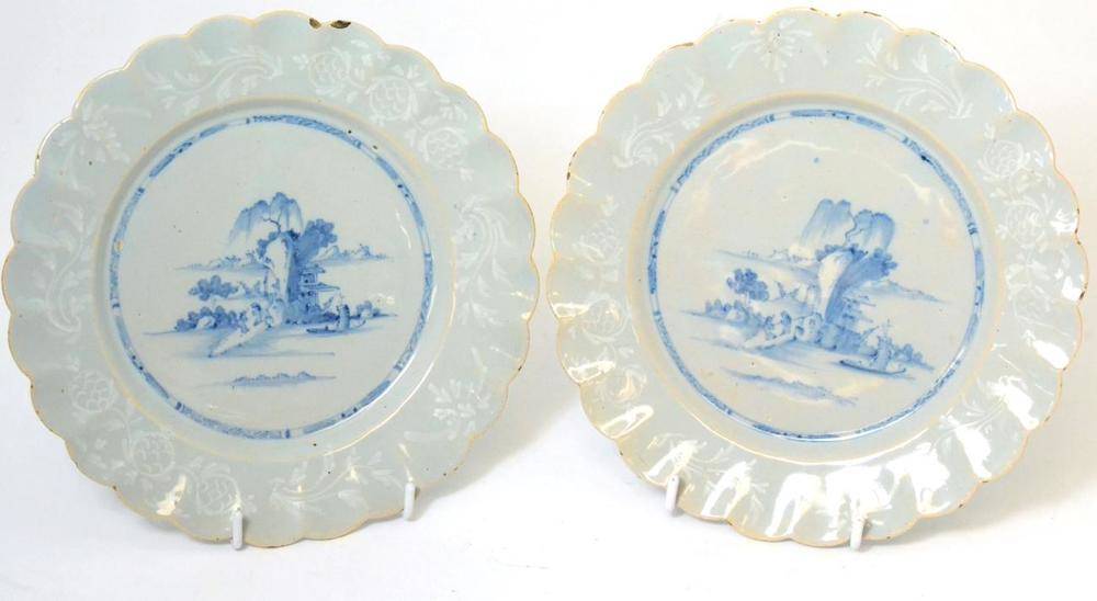 Lot 45 - A pair of English Delft plates, circa 1760, painted in blue with a boat before rocks within a...