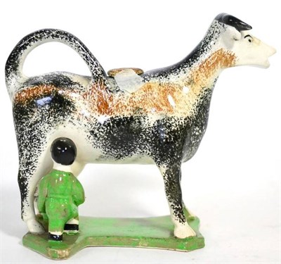 Lot 64 - A Prattware cow creamer and stopper, circa 1810, with milk maid, decorated in sponged black and...