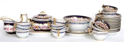 Lot 121 - ^ An English porcelain tea service, circa 1810, painted with bands of flowers on a blue and...