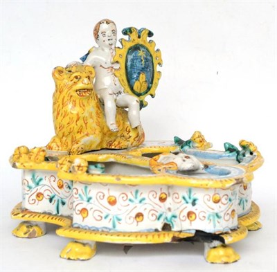 Lot 126 - Italian Maiolica desk stand in 17th century style surmounted by a putti holding a shield on a lion