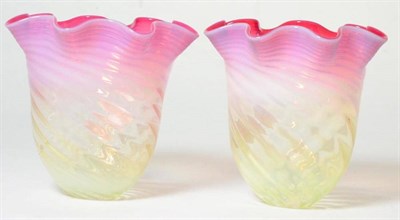 Lot 152 - A pair of cranberry and vaseline glass light shades of frilled form, 14cm high