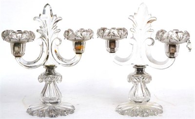 Lot 153 - A pair of cut glass twin light candelabra, early 19th century, with leaf finials and sockets on...