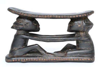 Lot 187 - A Shona wood headrest, carved as two seated figures holding hands, 29cm wide