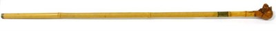 Lot 204 - A walking cane, circa 1900, the pommel carved as a dog with glass eyes wearing a jockeys cap,...