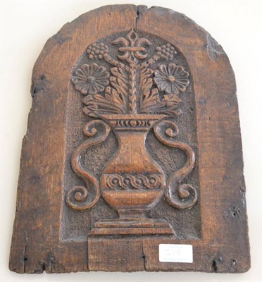 Lot 219 - A carved oak arched panel, 17th century, carved with a vase of flowers, 38cm by 28cm