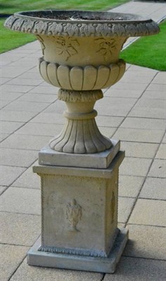 Lot 229 - A cast stone Campana urn on stand, 20th century, of semi-fluted form, the everted rim with stylised