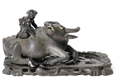 Lot 231 - A Chinese carved wood figure of an ox and rider, early 20th century, recumbent with bone eyes...