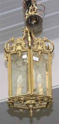 Lot 246 - A brass hexagonal hall lantern cast with scrolls and shells, the glass panels engraved with...