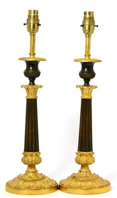 Lot 275 - A pair of French empire style gilt and patented bronze lamp bases with urn sockets, flute...