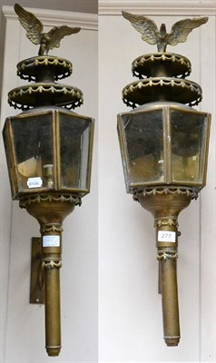 Lot 277 - A pair of brass wall lanterns, of hexagonal form with eagle finials, on scroll brackets, 74cm high