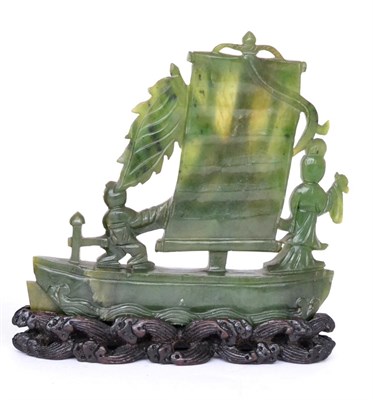 Lot 424 - A Chinese jade model of a sailing boat with two figures on desk, 11.5cm long, on a wooden stand