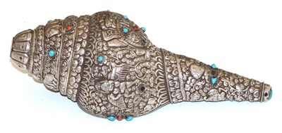 Lot 463 - A Sino-Tibetan white metal mounted conch shell, repoussé with deities and animals amongst...