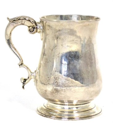 Lot 489 - A George III silver mug, Thomas Wallis II, London 1788, plain baluster form with leaf capped scroll