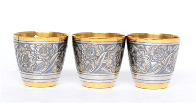 Lot 528 - A set of three Russian parcel gilt silver and niello vodka tots, 2nd half 20th century, 875...