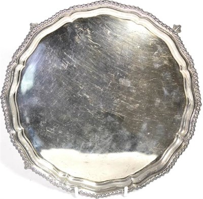 Lot 531 - A shaped circular silver salver, Olivant & Botsford, London 1961, with gadrooned border on ball and