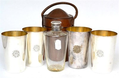 Lot 540 - A silver plate mounted spirit flask and four tumblers, engraved with monograms, in a leather...