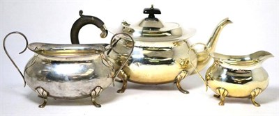 Lot 542 - A silver three piece tea service, Birmingham, 1921, plain oval on pad feet, the teapot, 29cm long