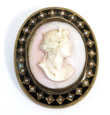 Lot 593 - A carved conch shell cameo brooch/pendant, depicting the bust of a Bacchante, within a black enamel