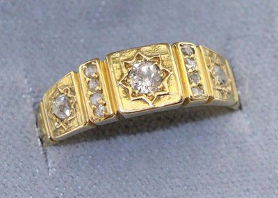 Lot 606 - A diamond band ring, three graduated old cut diamonds in star settings to square frames, spaced...