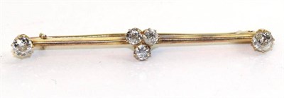 Lot 607 - A diamond bar brooch, a central cluster of three old cut diamonds in yellow claw settings to a...