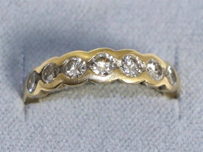 Lot 611 - A diamond half hoop ring, seven round brilliant cut diamonds in rubbed over settings, total...