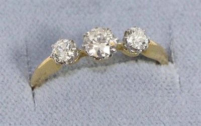 Lot 621 - A diamond three stone ring, graduated old cut diamonds in claw settings and spaced by knife...