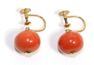 Lot 637 - A pair of coral earrings, large coral beads drilled to floral screw back fittings, measure 13mm...