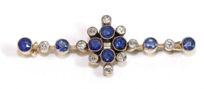 Lot 651 - A sapphire and diamond brooch, four round cut sapphires in yellow milgrain settings within a border