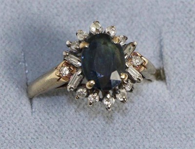 Lot 652 - A sapphire and diamond cluster ring, an oval cut sapphire within a border of eight-cut and baguette