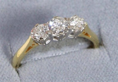 Lot 678 - An 18 carat gold diamond three stone ring, graduated round brilliant cut diamonds in claw settings