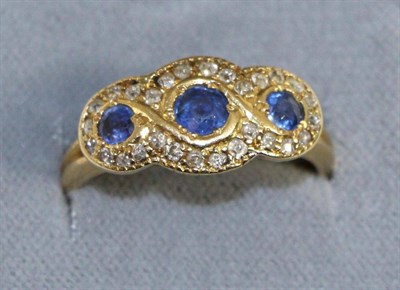 Lot 681 - An 18 carat gold sapphire and diamond triple cluster ring, three graduated round cut sapphires...