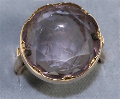 Lot 686 - An amethyst reverse intaglio ring, a round cut amethyst engraved with the bust of Mars, in a yellow