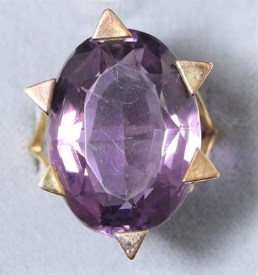 Lot 687 - An amethyst ring, a large oval cut amethyst in a 'star' claw setting, to forked shoulders,...