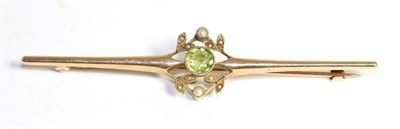 Lot 692 - An Art Nouveau peridot and seed pearl bar brooch, a round cut peridot in a milgrain setting...