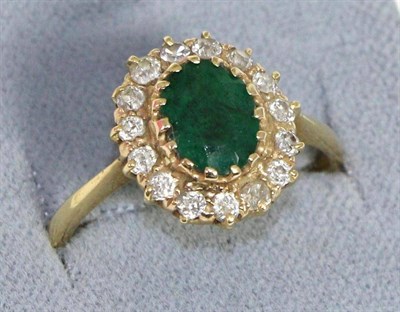 Lot 700 - An emerald and diamond cluster ring, an oval cut emerald within a border of old cut diamonds in...