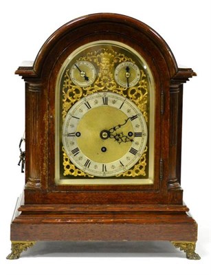 Lot 1322 - An oak chiming table clock, circa 1900, arched case, gilt metal pierced side frets, claw feet,...