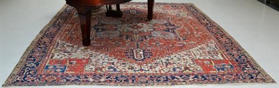 Lot 1337 - A Heriz carpet of unusual size Iranian Azerbaijan, the terracotta field of angular vines around...