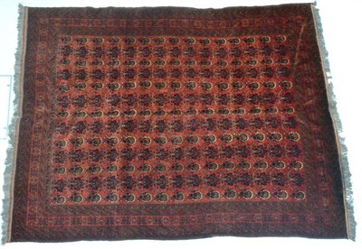 Lot 1348 - Afghan Turkman carpet, circa 1980, the terracotta field with an allover design of stylised...