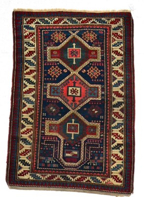 Lot 1351 - Antique Kazak prayer rug, Central Caucasus, the indigo field with three latch hook polychrome...