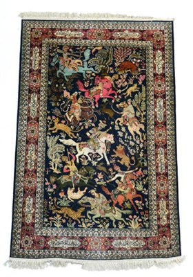 Lot 1366 - Kashmir silk rug, North west India the indigo field of hunting scene enclosed by coral pink...