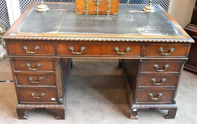 Lot 1408 - ^ A carved mahogany partners desk, late 19th/early 20th century, worn leather writing surface above