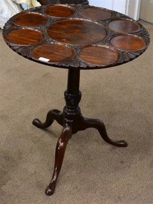 Lot 1409 - A carved mahogany tripod table, in George II style, the circular top with a moulded dished...