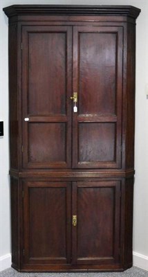 Lot 1414 - George III mahogany free standing corner cupboard, late 18th century, with four cupboard doors...