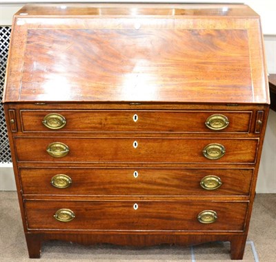 Lot 1418 - A George III mahogany boxwood and ebony strung fall front bureau, with four long drawers and raised