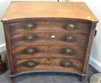 Lot 1423 - ^ A George III mahogany four drawer chest of drawers of concave shaped form, raised on square...