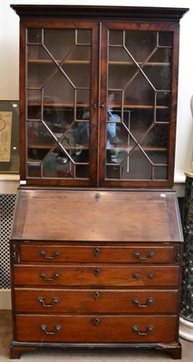 Lot 1426 - ^ A George III mahogany secretaire bookcase, early 19th century, with a Greek key dentil...