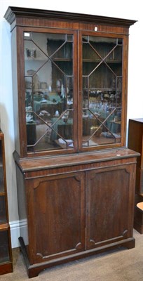 Lot 1437 - ^ A George III style mahogany bookcase with a bald pediment above astragal glazed doors...