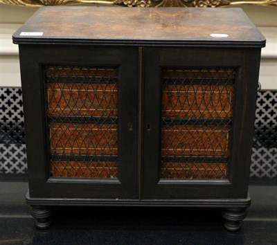 Lot 1472 - ^ A Victorian ebonised amboyna and cedar lined grill door cabinet enclosing four drawers with brass